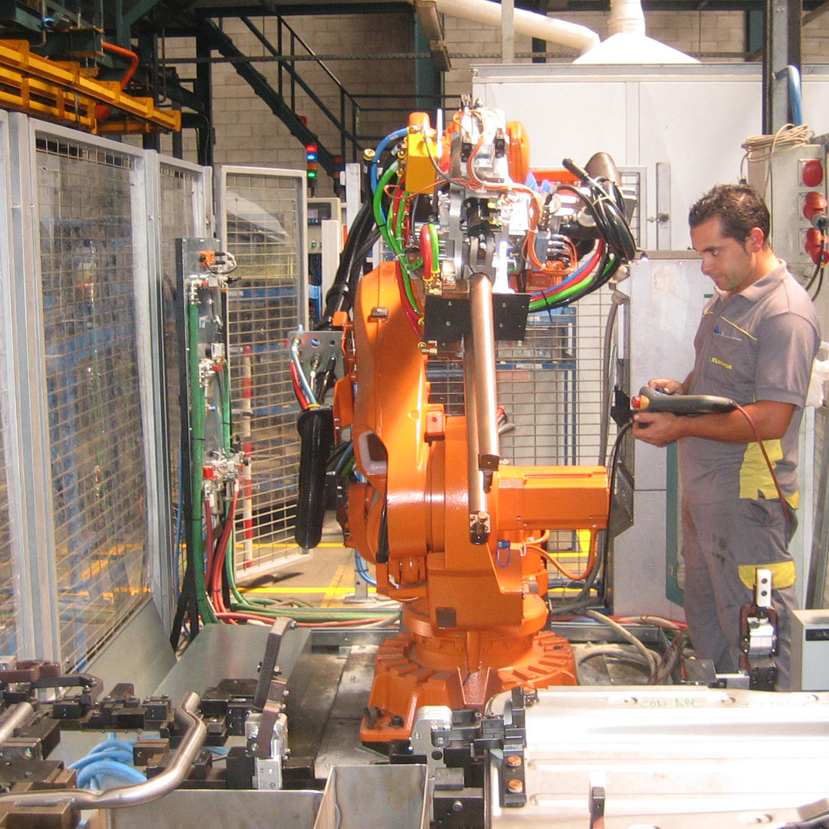 Operario de elecpor realizando tareas de mantenimiento en robot brazo articulado